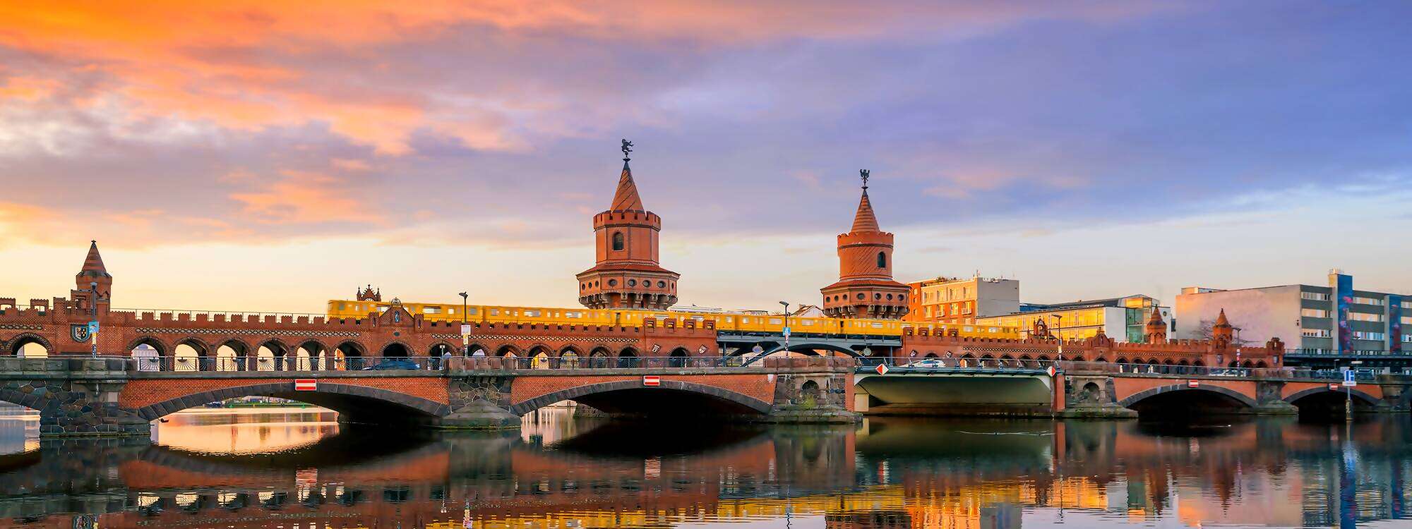 Berliner Skyline mit der Oberbaumbruecke an der Spree bei Sonnenaufgang in Deutschland